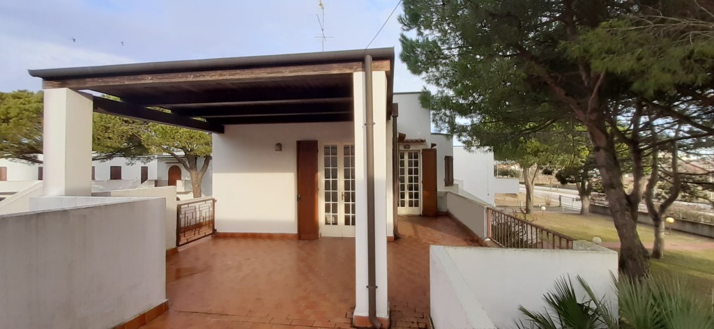Terrazza ampia con copertura, vista su verde e giardino, situata in una villetta al primo piano.