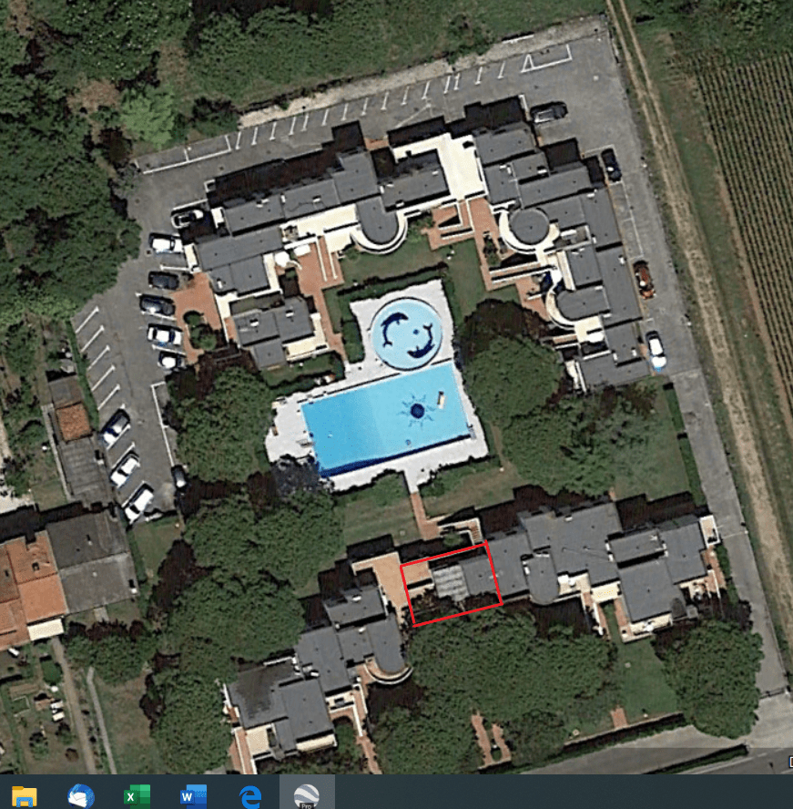 Immagine satellitare di un residence con piscine, evidenziando una villetta al primo piano, circondata da alberi e spazi verdi.